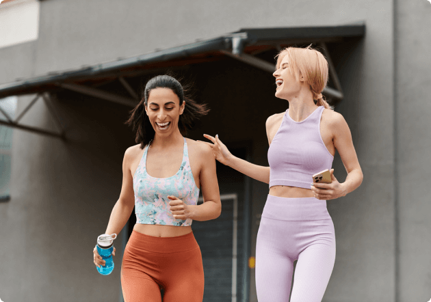 2 vrouwen zijn lachend samen aan het hardlopen