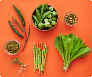 oranje achtergrond met verschillende soorten groeten, zoals asperges, spruiten, tuinbonen, sla , etc.