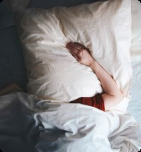 persoon ligt vermoeid in bed