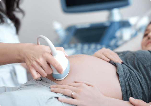 vrouw ligt bij de dokter voor een echo van haar baby