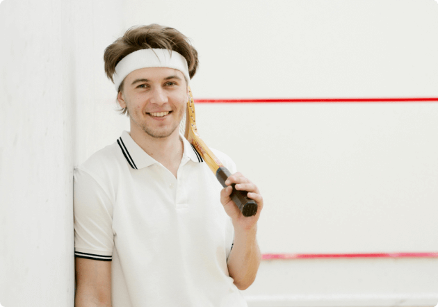lachende jongen op een squash baan