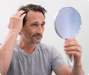 man kijkt in de spiegel naar zijn haar