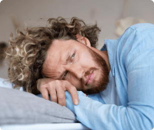 man ligt vermoeid met zijn hoofd op de bank