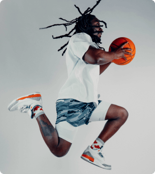 man springt met basketbal in zijn handen en heeft jordan 3 aan