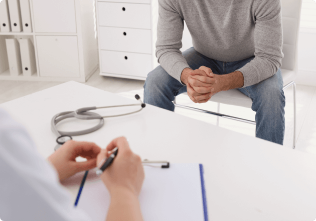 man zit op de stoel bij de dokter voor een consult