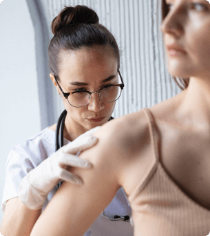 vrouwelijke dokter inspecteert schouder van patiënt