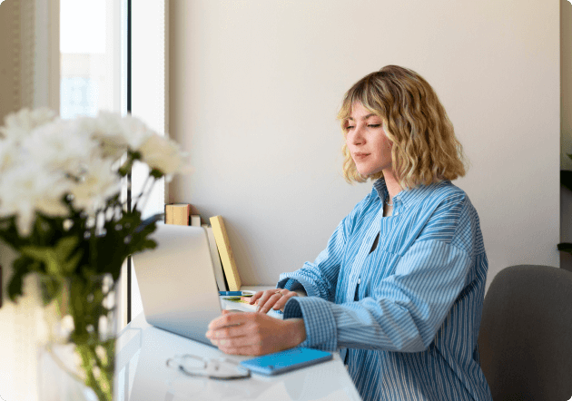 vrouw zit te werken achter haar laptop